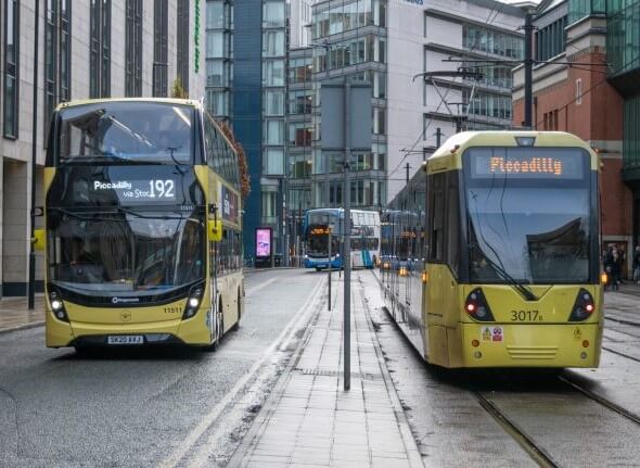 Decorative image of a yellow Bee Network bus and a yellow Metrolink tram on the street