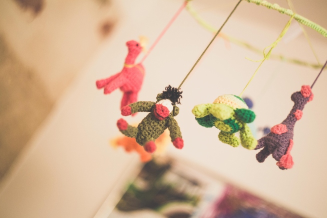 a baby mobile with knitted animals