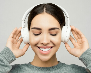 a woman with dark hair wearing white headphones