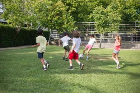 girls and boys playing football on a field