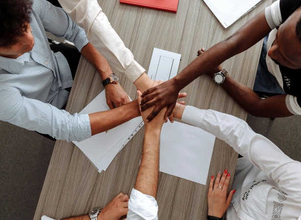 a group of people putting hands in 