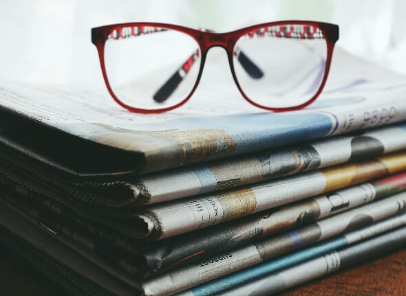 Glasses on top of Newspaper to indicate spotting Fake News