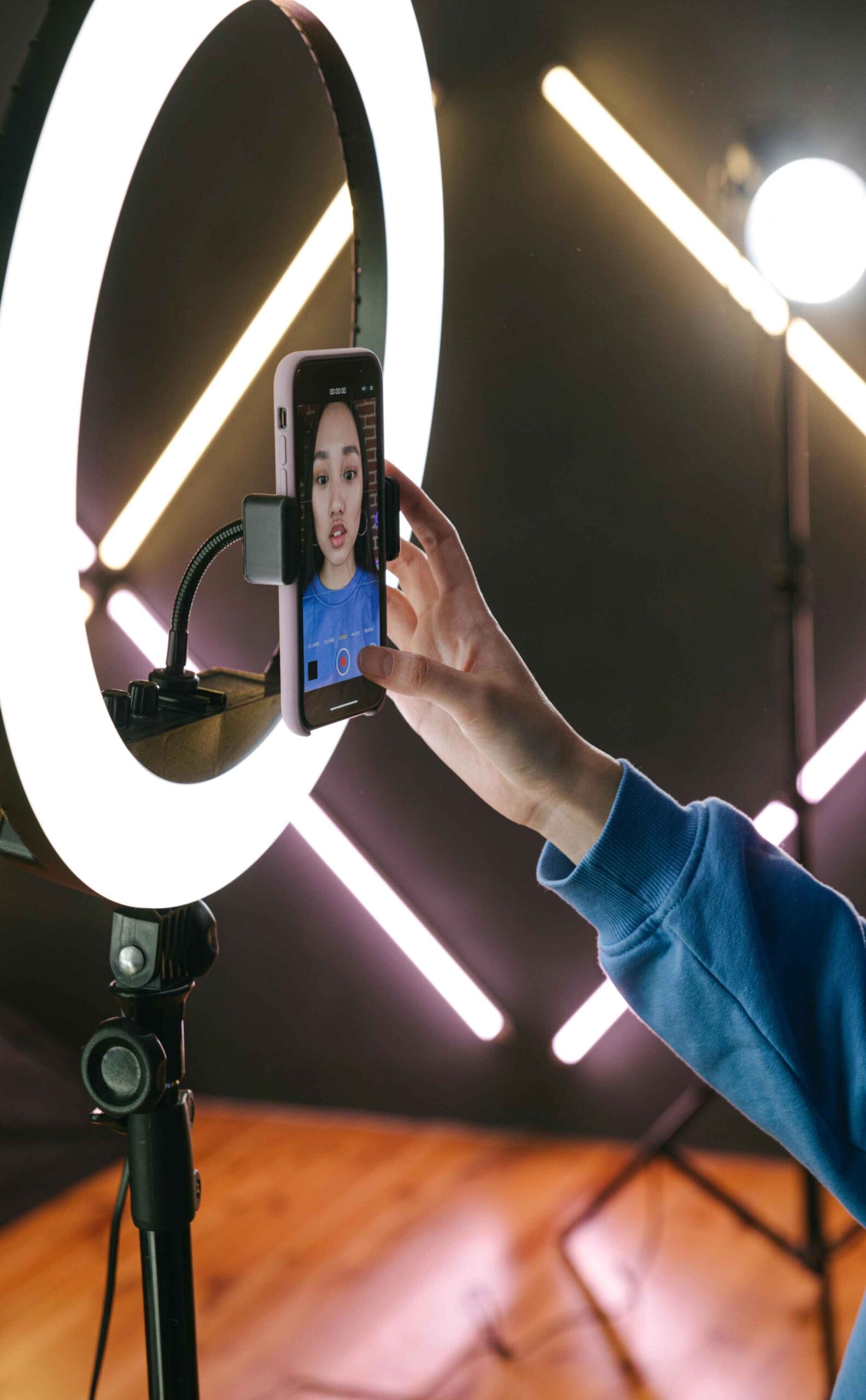 Influencer image 2 (1) A ring light with a mobile phone in the middle showing the image of a girl about to record herself