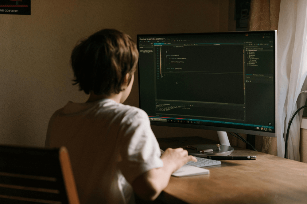 cyber security image 2 A young person sat at a computer with code visible on the screen