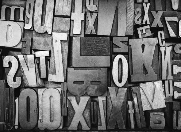 black and white theme of letters of different sizes scattered across a board