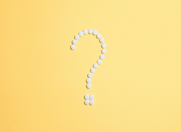 a question mark made of white beads on a yellow background