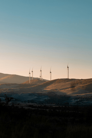 Wind Turbines on hills with a dusk setting.